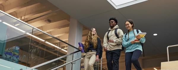 Three MGA students walking down the stairs at the Roberts Memorial Library.